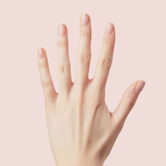 Hand with nails painted in neutral mauve using The Queen Takes her Tea with Milk for a natural Olive and June mani