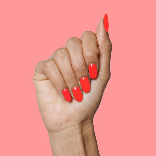 Hand displaying a smooth, glossy Lava nail polish manicure in bright spicy orange-red on coral background