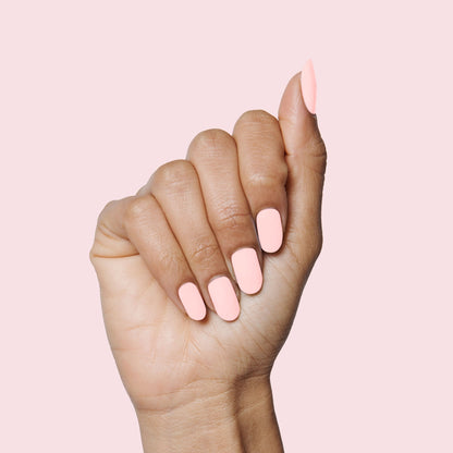 Hand showcasing SCL soft bubblegum pink gel polish on neatly shaped nails against a pale pink background for a mani