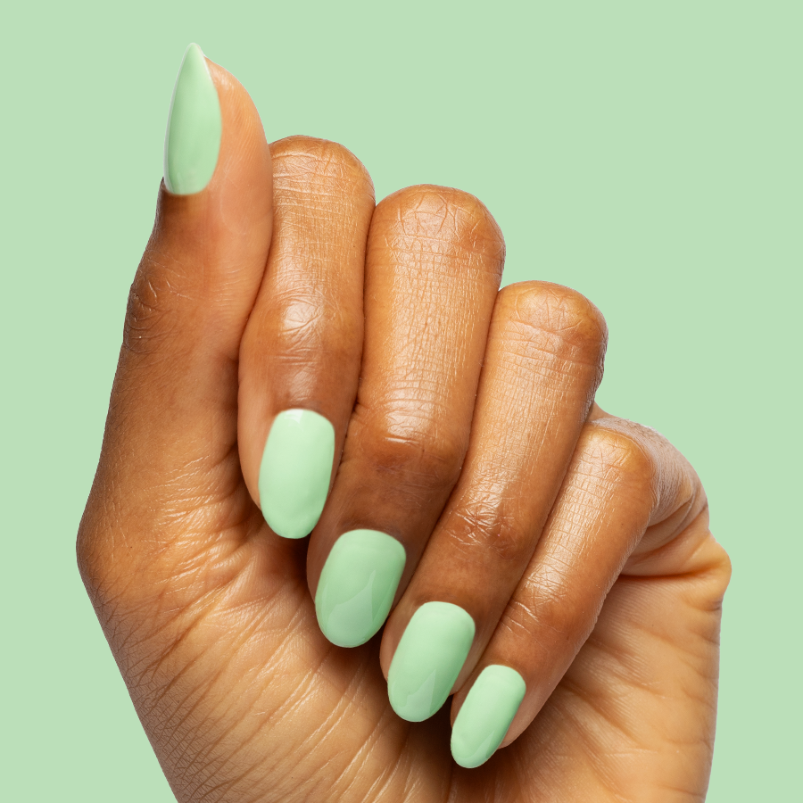Hand with nails polished in pastel green using Aced It - Gel for a smooth, long-lasting at home mani look