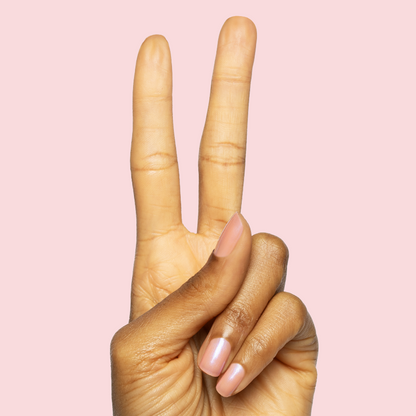 Hand showing peace sign with nails painted in sheer iridescent bubble gum pink polish Olive Y'all manicure