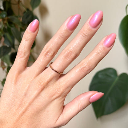 Hand with almond-shaped nails painted bright bubble gum pink-blue iridescent using Olive Y’all - Gel polish