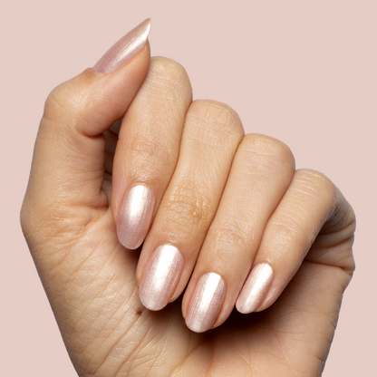 Hand with softly rounded nails painted in sheer shimmering pink Supernova quick dry polish manicure